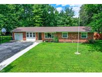 Charming brick home with a well-manicured lawn, mature trees, and a basketball hoop at 4132 Tincher Rd, Indianapolis, IN 46221