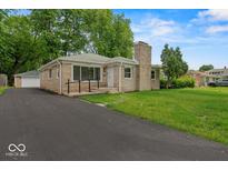 Charming single-story home featuring a stone facade, well-manicured lawn, and a paved driveway at 508 W 38Th St, Indianapolis, IN 46208