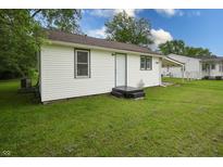 Back exterior view of home with white siding and green grass at 523 Patterson Rd, Columbus, IN 47203