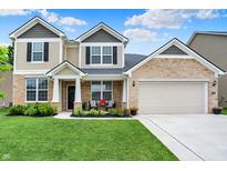 Beautiful two-story home with manicured lawn, stone accents, neutral siding, and covered front porch at 5306 Lavender Dr, Plainfield, IN 46168