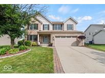 Charming two-story home with brick facade, two-car garage, manicured lawn, and beautiful landscaping at 5960 Dado Dr, Noblesville, IN 46062