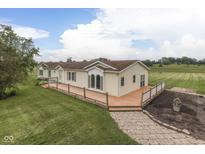 Charming, ranch-style home with a large wooden deck overlooking a spacious yard and agricultural field at 5964 N Pr Wind Drift Ln, Shelbyville, IN 46176