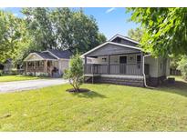 Charming home with inviting front yard and two-tone neutral color scheme at 6029 English Ave, Indianapolis, IN 46219