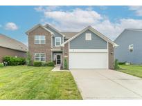Charming two-story home with a brick and vinyl facade, landscaped yard, and attached two-car garage at 6737 Trey Dr, Camby, IN 46113