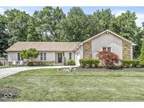 Charming single-story home with a well-manicured lawn, stone accents, and an inviting, curved driveway at 792 Nevelle Ln, Carmel, IN 46032