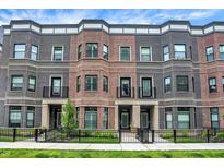 Beautiful townhomes featuring brick and wrought iron accents, plus manicured front yard at 906 Berkhamsted Ln, Carmel, IN 46032