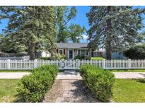 Charming home featuring a white picket fence, mature trees, and lush green bushes at 917 W Busby St, Lebanon, IN 46052