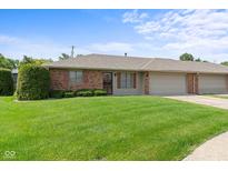 Charming brick exterior with a lush green lawn and attached garage on a sunny day at 1309 Wyoming Way, Anderson, IN 46013