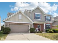 Two story home featuring brick and siding with a two car garage and manicured lawn at 14453 Glapthorn Rd, Fishers, IN 46037