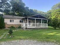 Charming home featuring a covered front porch, stone accents, and a well-maintained lawn at 162 W Robertson Rd, Morgantown, IN 46160