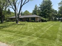 Charming ranch-style home with a well-manicured lawn and mature trees in a quiet, residential neighborhood at 2937 S Allen Dr, New Palestine, IN 46163