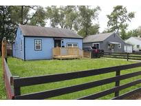 Charming blue home with new porch and black picket fence, offers a blend of comfort and style at 3201 W 22Nd St, Indianapolis, IN 46222