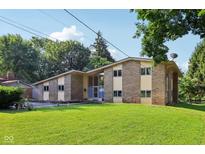 Charming brick home boasts a well-manicured lawn and mature trees at 3265 Tulip Dr, Indianapolis, IN 46227