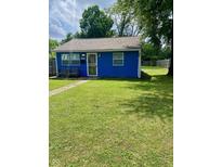 Charming blue single-story home featuring a well-manicured lawn and cozy front porch seating at 3464 N Bancroft St, Indianapolis, IN 46218