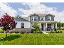 Charming two-story home featuring manicured lawn, landscaping, and a welcoming front porch at 3606 Evergreen Way, Zionsville, IN 46077