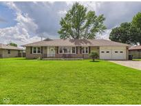 Charming single-story home with a lush green lawn and attached two car garage at 3809 N Glenwood Ave, Muncie, IN 47304