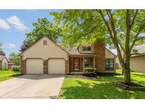 Inviting home showcasing a two-car garage, brick accents, manicured lawn, and mature trees at 4291 Caledonia Way, Indianapolis, IN 46254