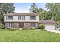 Charming brick and siding home with a well-manicured lawn and beautiful landscaping at 4431 Cranbrook Dr, Indianapolis, IN 46250
