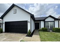 Charming home featuring a black garage door, white siding, and a well-manicured lawn at 4726 Deacon Ln, Indianapolis, IN 46237