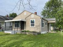 Charming single-Gathering home features a covered front porch, brick accents, and a well-manicured lawn at 602 S Sherman Dr, Indianapolis, IN 46203