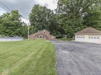 Charming brick home with a two-car garage, above-ground pool and lush green lawn at 6295 State Road 142 Rd, Martinsville, IN 46151