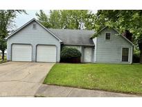Charming home with a two-car garage, manicured lawn, and classic architectural design details at 7042 Colita More Ct, Indianapolis, IN 46254
