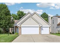 Charming two-story home featuring a two-car garage, brick accents, and a well-manicured lawn, offering an inviting curb appeal at 829 Pioneer Woods Dr, Indianapolis, IN 46224