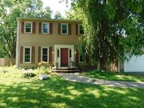 Charming two-story home featuring classic siding, a welcoming red front door, and well-maintained landscaping at 8425 E 82Nd E St, Indianapolis, IN 46256