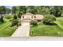 Charming two-story home with a well-maintained lawn and beautiful landscaping at 8525 Winding Ridge Rd, Indianapolis, IN 46217