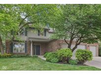 Charming two-story home with brick and vinyl siding, complemented by lush landscaping and a three-car garage at 9643 Cypress Way, Carmel, IN 46032