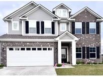 Charming two-story home featuring a brick and vinyl facade with a well-manicured lawn and attached two-car garage at 10218 Arctic Edge Dr, Indianapolis, IN 46259