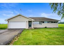 Charming single-story home with attached garage, lush lawn, and a welcoming front entrance at 10500 S County Road 200 W, Muncie, IN 47302