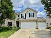 Charming two-story home features brick and vinyl siding, dark shutters, and a spacious three-car garage at 13859 Keams Dr, Fishers, IN 46038