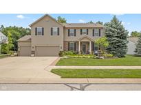 Charming two-story home with a well-manicured lawn, three-car garage, and lovely front porch at 1393 Turfway Dr, Avon, IN 46123