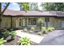 Inviting home entrance with manicured landscaping and a charming stone and timber facade at 14407 Bryn Mawr Dr, Fishers, IN 46038
