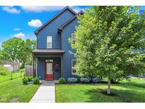 Charming two-story home with blue siding, a red door, and a well-manicured lawn, offering great curb appeal at 2720 Guilford Ave, Indianapolis, IN 46205
