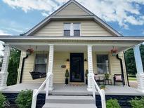 Charming home featuring a covered front porch with decorative columns and a cozy porch swing at 3015 Mckinley Ave, Columbus, IN 47201