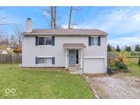 Charming two-story home with light siding, blue shutters, covered entryway and attached one car garage at 6120 E Southport Rd, Indianapolis, IN 46237