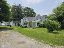 Charming home featuring a spacious front yard and white exterior with a cozy porch at 7831 E 46Th St, Indianapolis, IN 46226