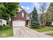 Charming two-story brick home with a well-maintained lawn and mature trees at 8877 N White Tail Trl, McCordsville, IN 46055