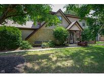 Charming two-story home featuring stone accents, a well-manicured lawn, and inviting front porch with seating at 919 Dreamy St, Greenwood, IN 46142