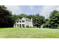 Charming two-story home with a well-manicured lawn and mature trees, perfect for outdoor enjoyment at 9710 Iroquois Ct, Indianapolis, IN 46256