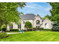 Stunning exterior view of a brick home with a manicured lawn and beautiful landscaping at 1037 Deer Lake Dr, Carmel, IN 46032