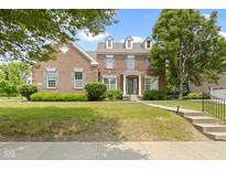 Charming two-story brick home with manicured lawn, mature trees, and classic architectural details at 13624 Alston Dr, Fishers, IN 46037