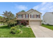 Charming two-story home featuring a well-manicured lawn and a long driveway leading to an attached garage at 14523 Lee Stewart Ln, Fishers, IN 46038
