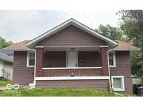Charming brown exterior showcasing the home's covered porch and classic architectural style at 1521 N Tacoma Ave, Indianapolis, IN 46201