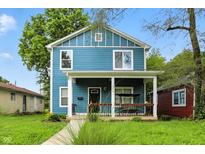 Charming two-story home with a welcoming front porch and a swing for relaxing, and manicured front lawn at 3210 Hovey St, Indianapolis, IN 46218