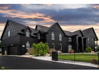 Elegant home with a black exterior, arched windows, a charming front yard, and a secure fence at 3306 Mullinix Rd, Greenwood, IN 46143