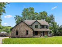 Charming two-story home with brick and siding, a well-manicured lawn, and a welcoming front porch at 3931 Tekesbury Ct, Plainfield, IN 46168