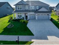 Inviting two-story home featuring a well-manicured lawn, spacious driveway, and a charming two-car garage at 4281 Viewforth Ln, Bargersville, IN 46106